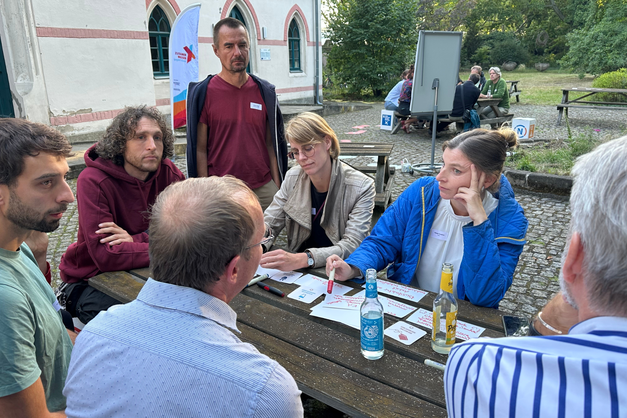 Worldcafé "Landtag trifft Zivilgesellschaft" - Teilnehmende sitzen um einen Tisch herum